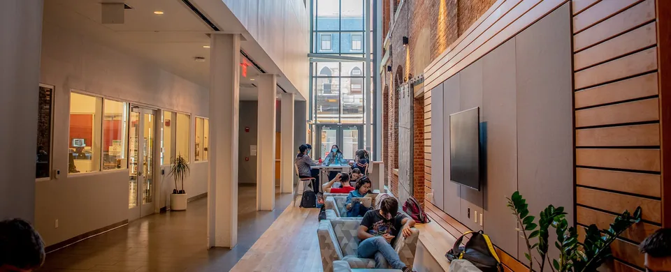 Study corridor with lounge chairs, a tall window and an old brick wall, Gateway Academic Center